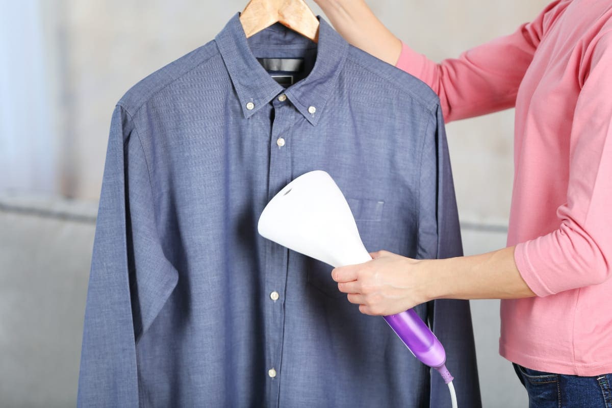 using garment steamer to steam clothes